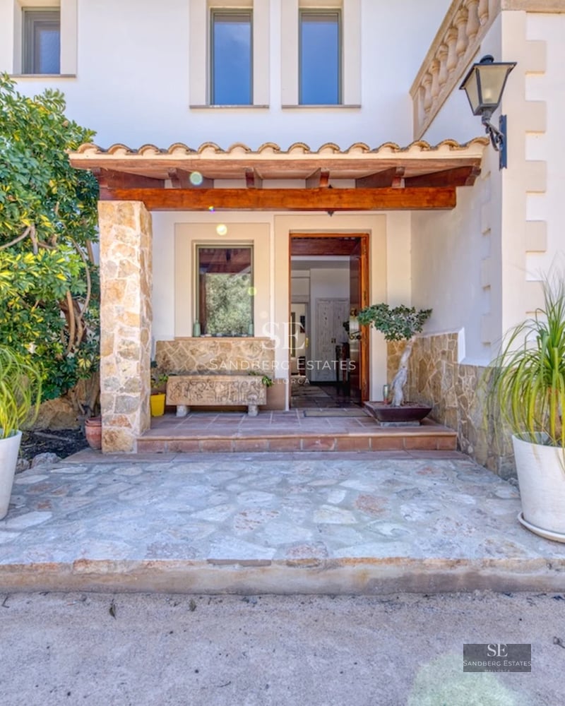 View of a modern villa with infinity pool, sun loungers, and lush vegetation. Sleek architectural design with large windows.