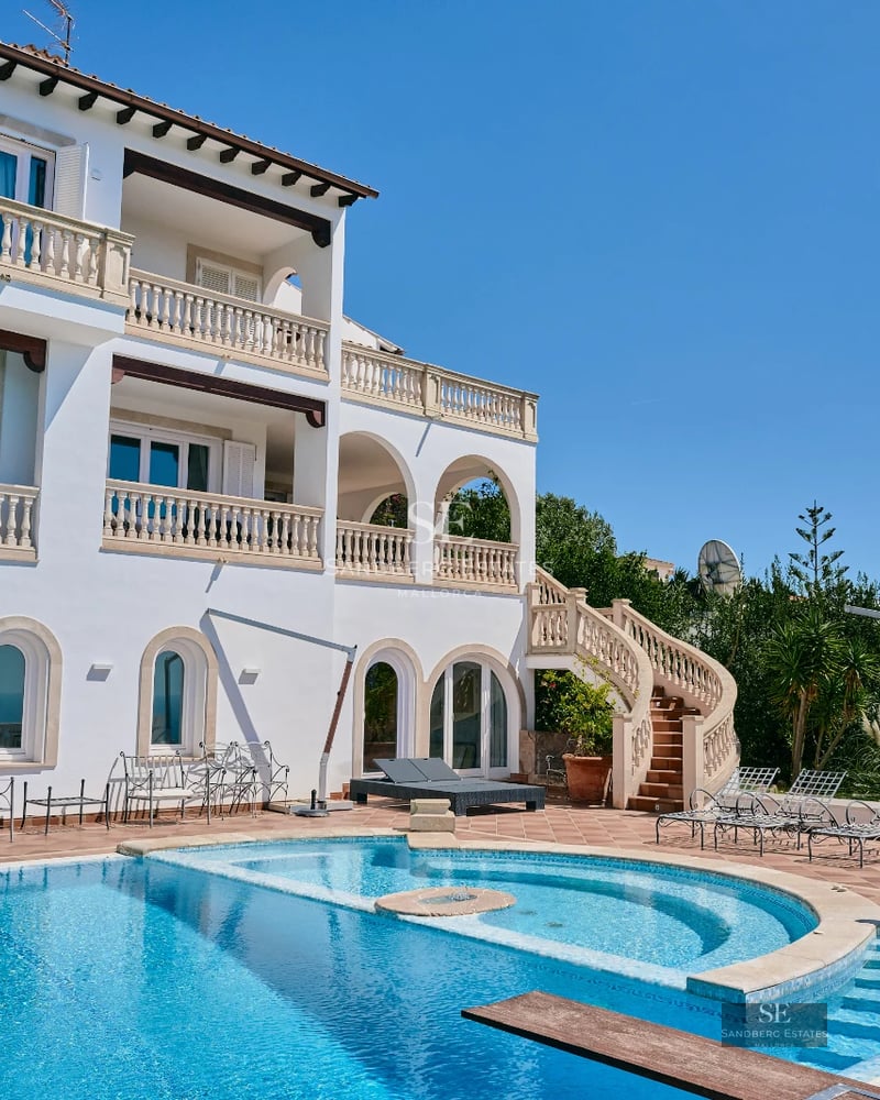 Expansive terrace with infinity pool and panoramic views. Modern design with wood flooring and elegant furniture. Warm ambient lighting.