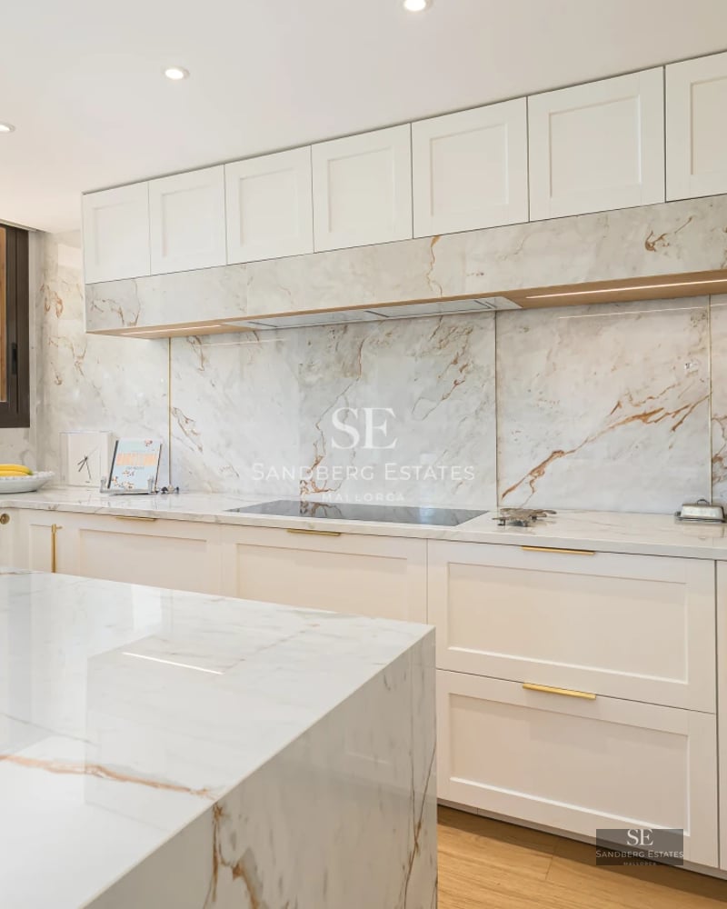 Modern living room with balcony, large windows, light wood floors, and designer furniture. Abundant natural light.