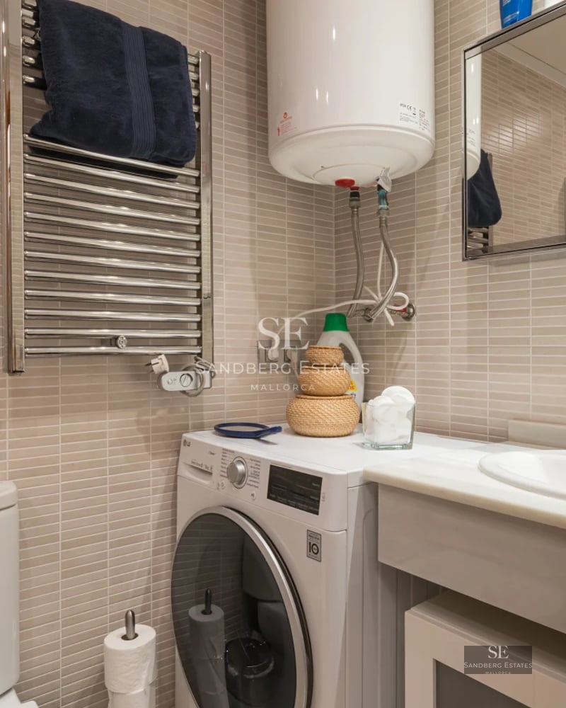 View of a luxurious swimming pool surrounded by lush greenery and a modern house with large windows.