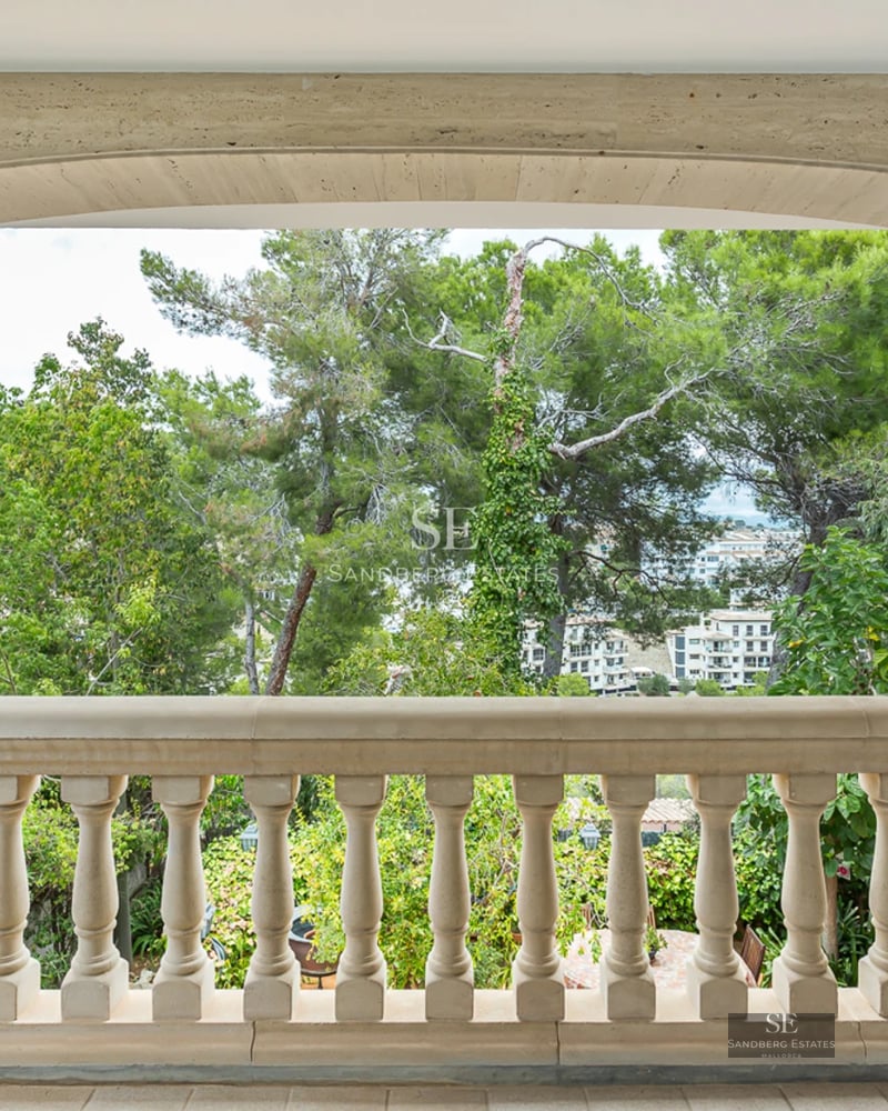 Spacious living room with panoramic windows, modern fireplace, light wood floors, and contemporary designer furniture. Sea view.