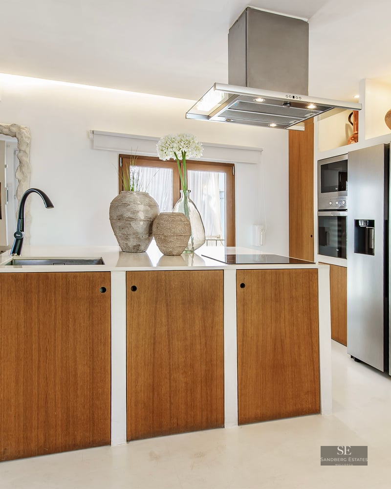 Contemporary kitchen featuring a wooden island, white countertops, and a stainless steel smart refrigerator.
