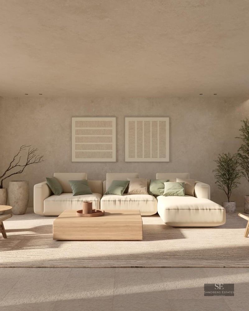 Spacious modern living room with cream sofa, wooden furniture, and floor-to-ceiling windows overlooking greenery.