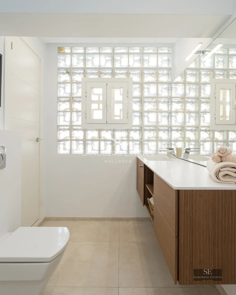 Exterior view of a modern villa with an infinity pool. Minimalist design, large windows, lush garden, and blue sky.