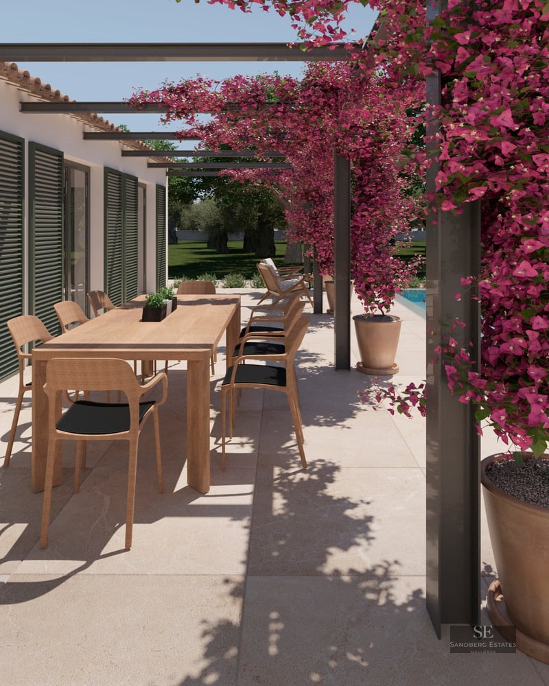 A sun-drenched outdoor terrace with a wooden dining table, pink bougainvillea climbing a pergola, and a turquoise pool.