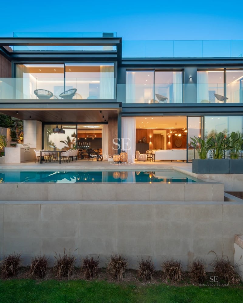 Modern villa exterior with reflective pool, manicured lawn, and minimalist architecture. Soft ambient lighting.