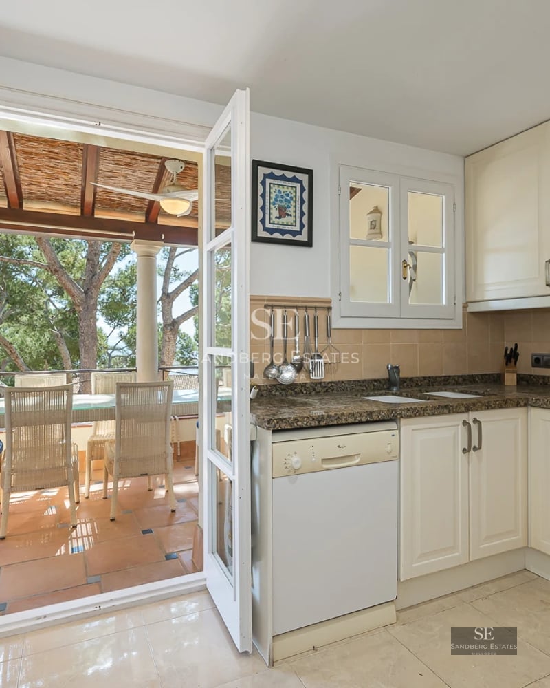 Spacious living room with large windows, light wood floors, modern furniture and access to terrace with panoramic views.