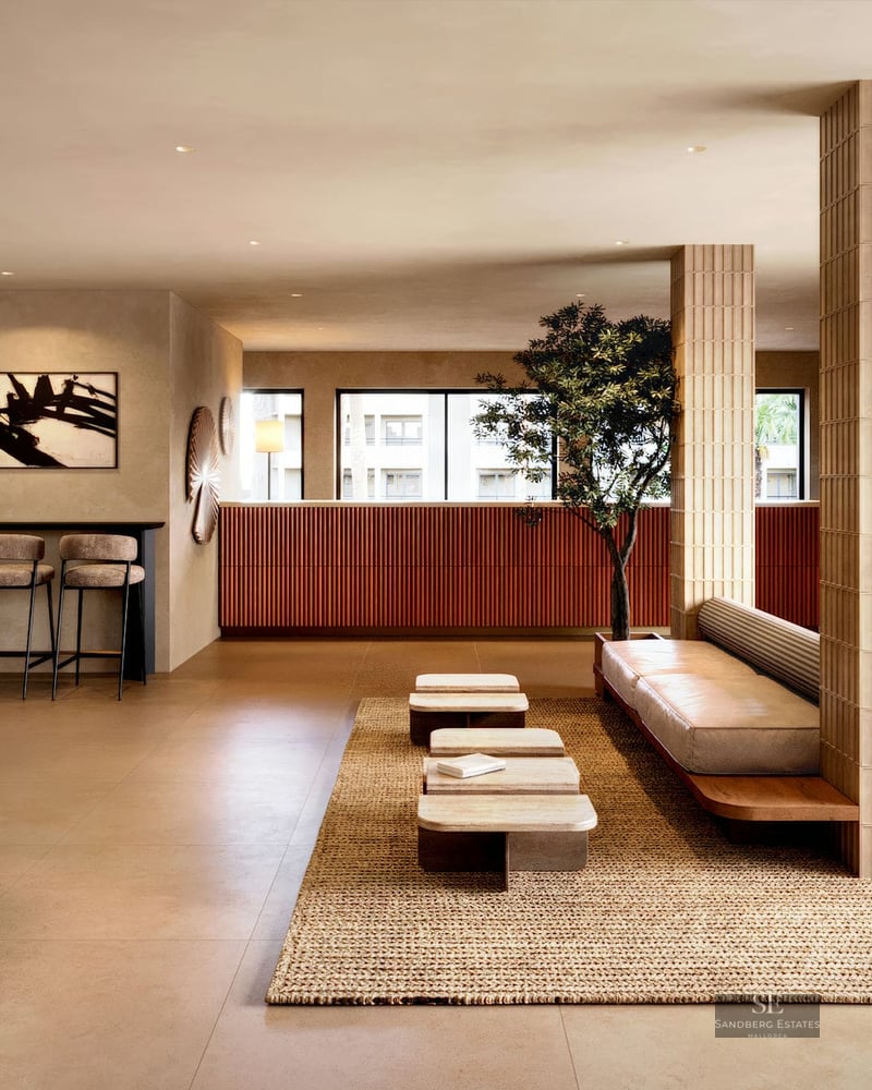 Hall contemporain avec colonnes en bois cannelé, banquette en cuir, tables en travertin et accents terre cuite.