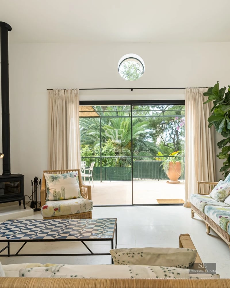 View of an elegant pool surrounded by lush greenery. Modern architecture with large windows and landscaping. Soft lighting.