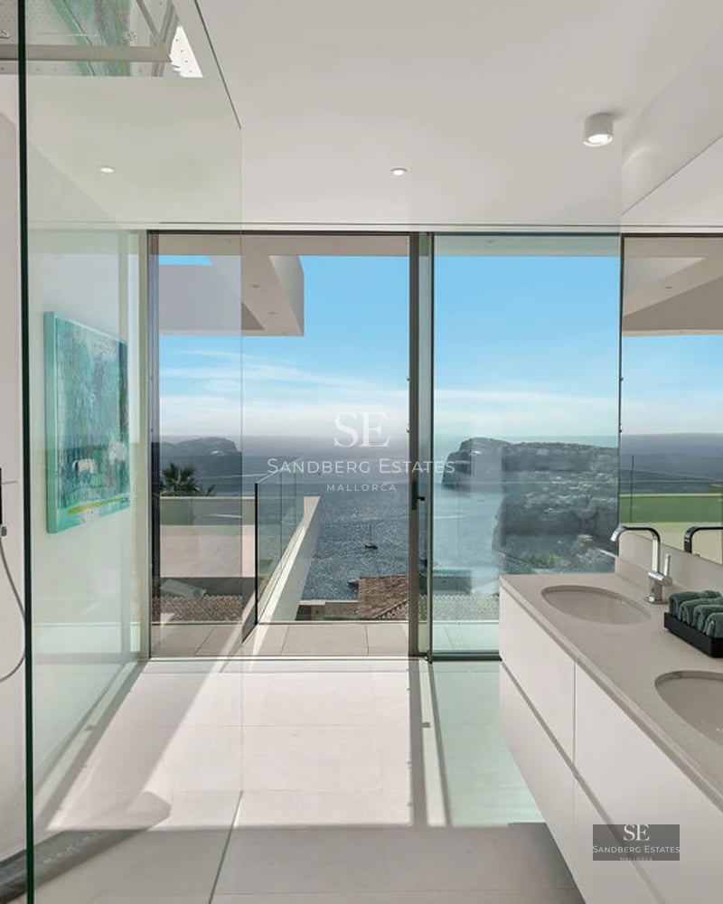 Large balcony with glass railing, modern furniture, and stunning view. Minimalist and elegant design. Abundant natural light.