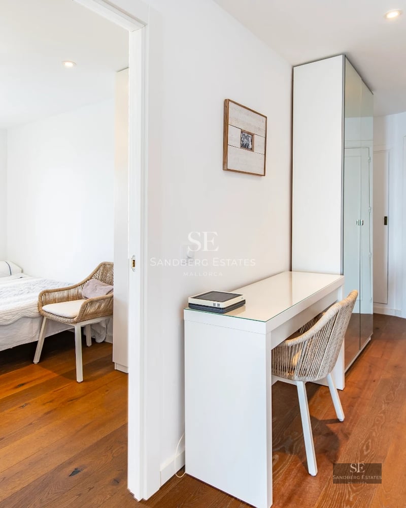 Exterior view of a modern villa with a pool, garden, and large windows reflecting sunlight. Minimalist and elegant design.