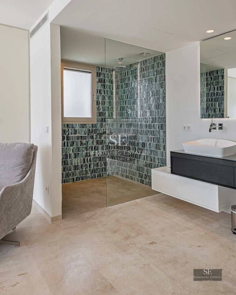 Bright living room with large windows offering panoramic sea views. Modern design, neutral colors, and luxurious furniture.