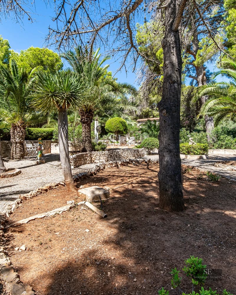 Spacious outdoor area with infinity pool, sun loungers, landscaped garden, and modern architecture. Elegant and relaxing design.