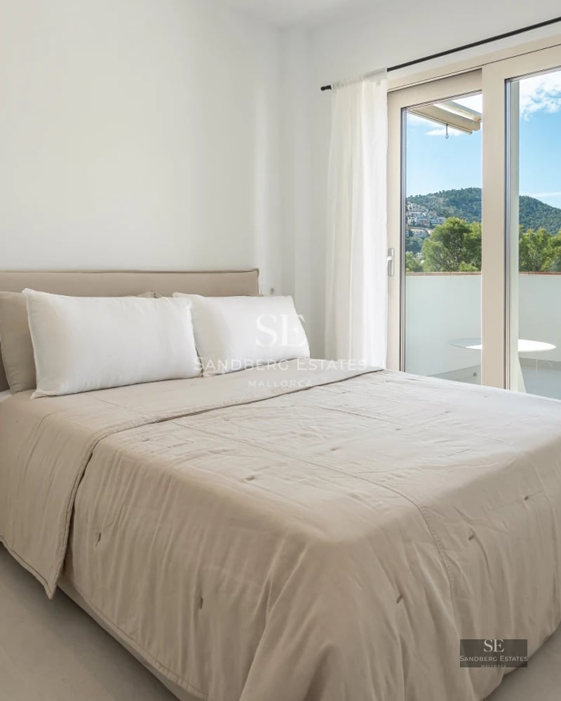 Expansive pool surrounded by lush vegetation and a modern villa with large windows. Minimalist and elegant design.