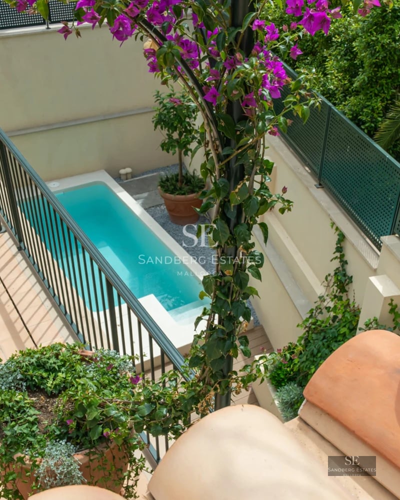 View of a modern villa with infinity pool, lush garden, and expansive terraces. Minimalist architecture and luxury finishes.