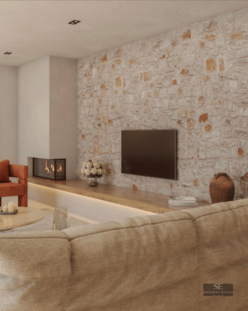 Modern living room featuring an exposed stone wall, burnt orange armchairs, a beige sofa, and a built-in fireplace.
