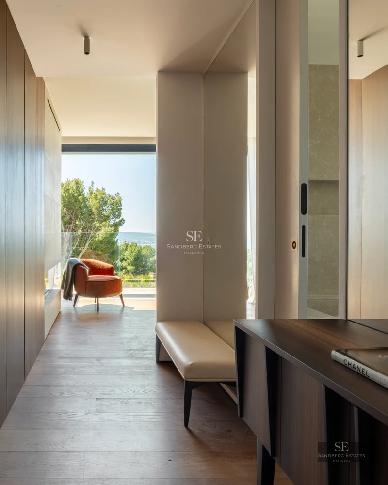 Spacious living room with floor-to-ceiling sea view windows, light wood floors, and minimalist design. Panoramic views and abundant natural light.