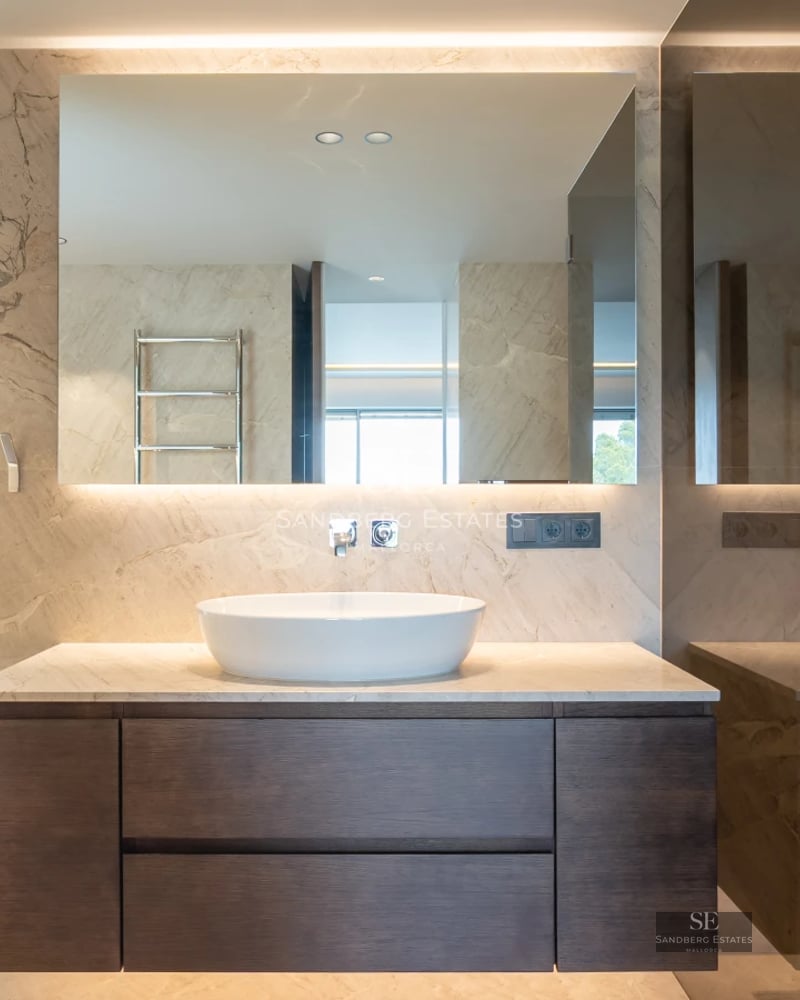 Exterior view of a modern house featuring a pool, garden, and large windows reflecting light. Minimalist architecture.