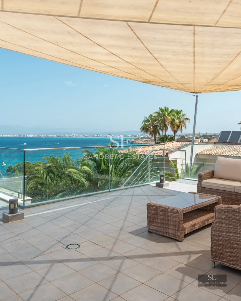Expansive terrace with infinity pool, sun loungers and panoramic sea views. Modern design with elegant furniture and lush greenery.
