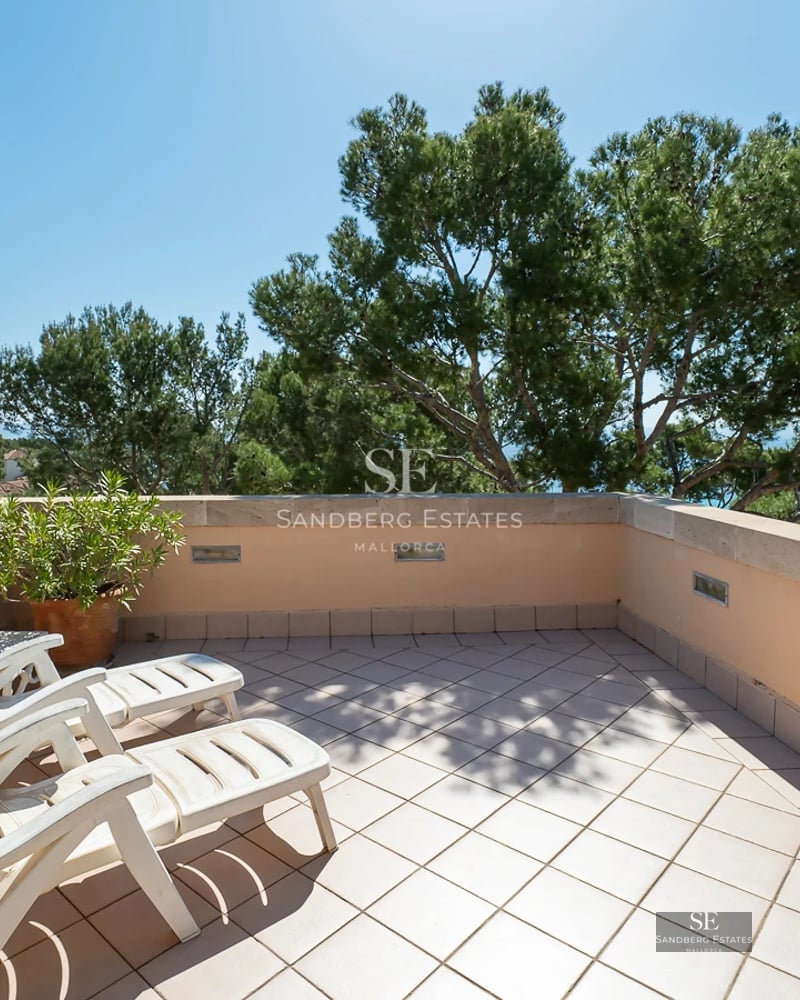 Bright living room with floor-to-ceiling windows overlooking the pool. Modern design, light floors, minimalist furniture, and unobstructed views.