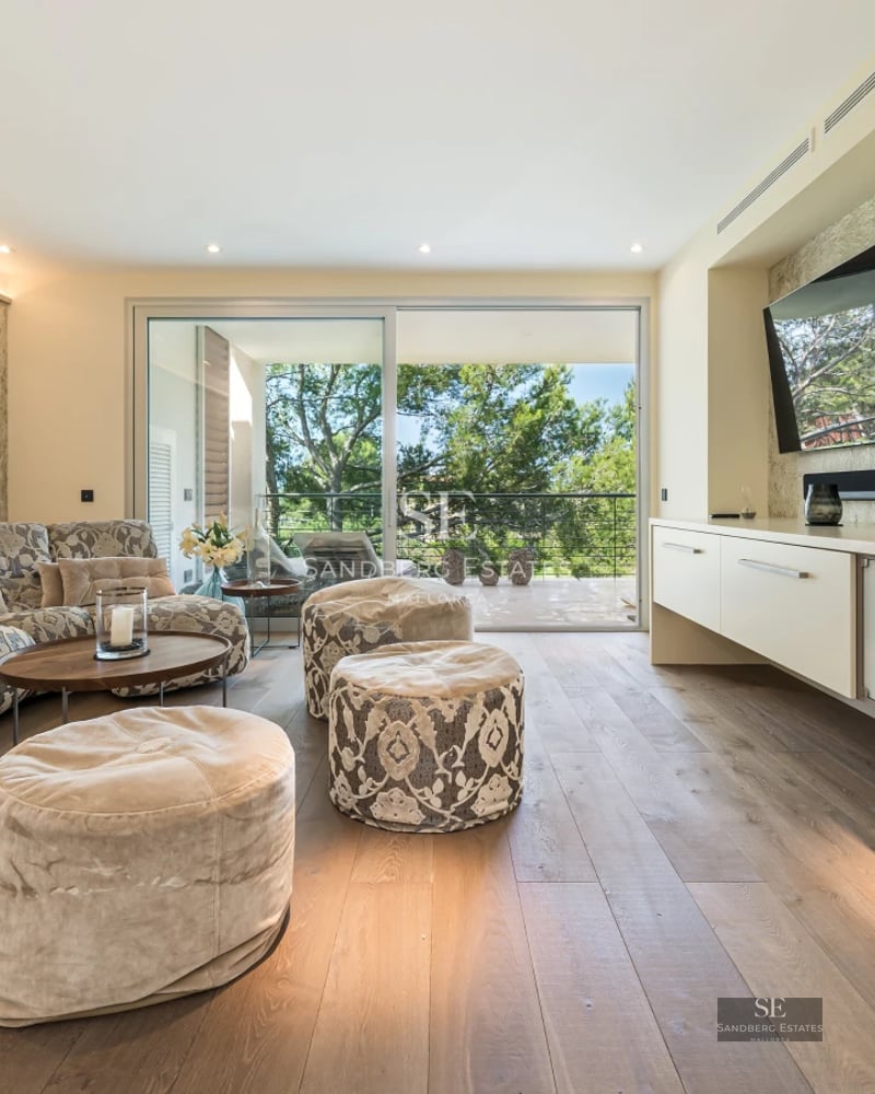 View of a luxurious pool with garden and an elegant modern home. Minimalist design features large windows and lush greenery.