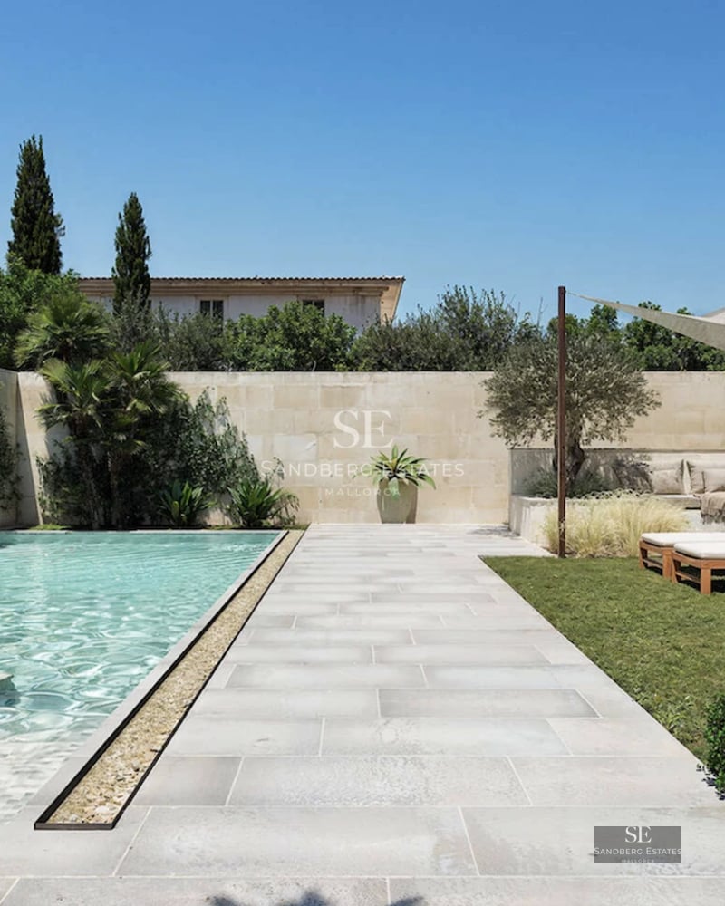 Bright living room with large windows, modern fireplace, and designer sofas. Panoramic views and elegant decor.