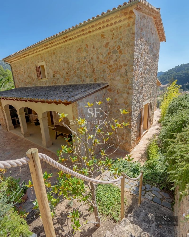 Spacious, bright living room with sea view. Sectional sofa, modern rug, large windows and minimalist decor.