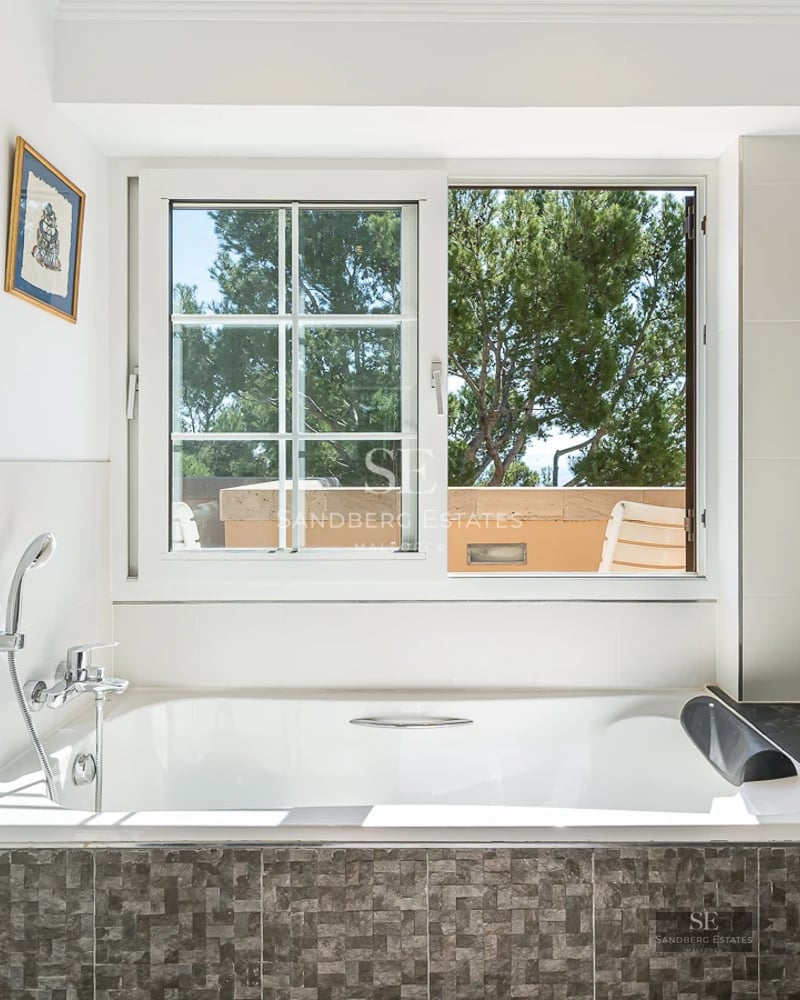 Exterior view of a modern villa featuring an infinity pool, large windows, and lush landscaping. Minimalist and elegant design.