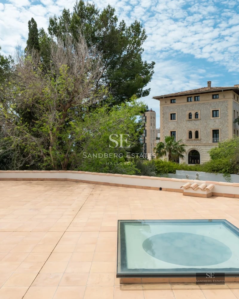 Exterior view of a modern villa featuring a reflecting pool, manicured lawn, and minimalist architectural design. Soft ambient lighting.