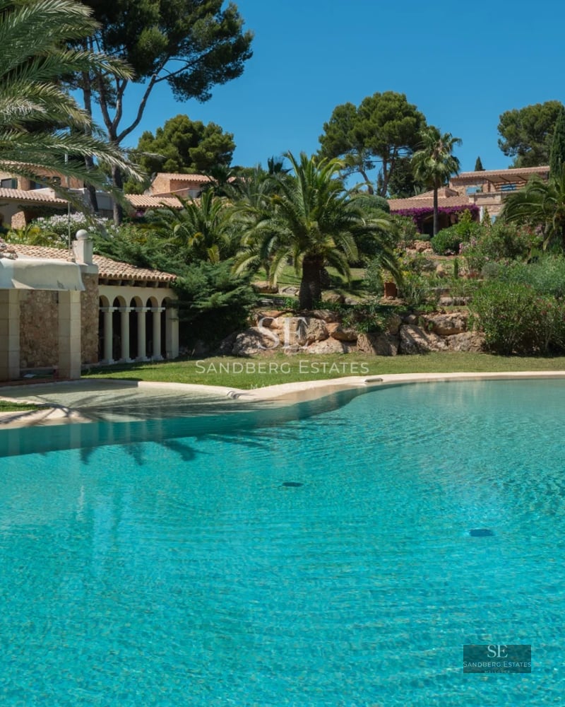 Exterior view of a modern villa with pool, large windows, garden, and minimalist architecture. Warm ambient lighting.