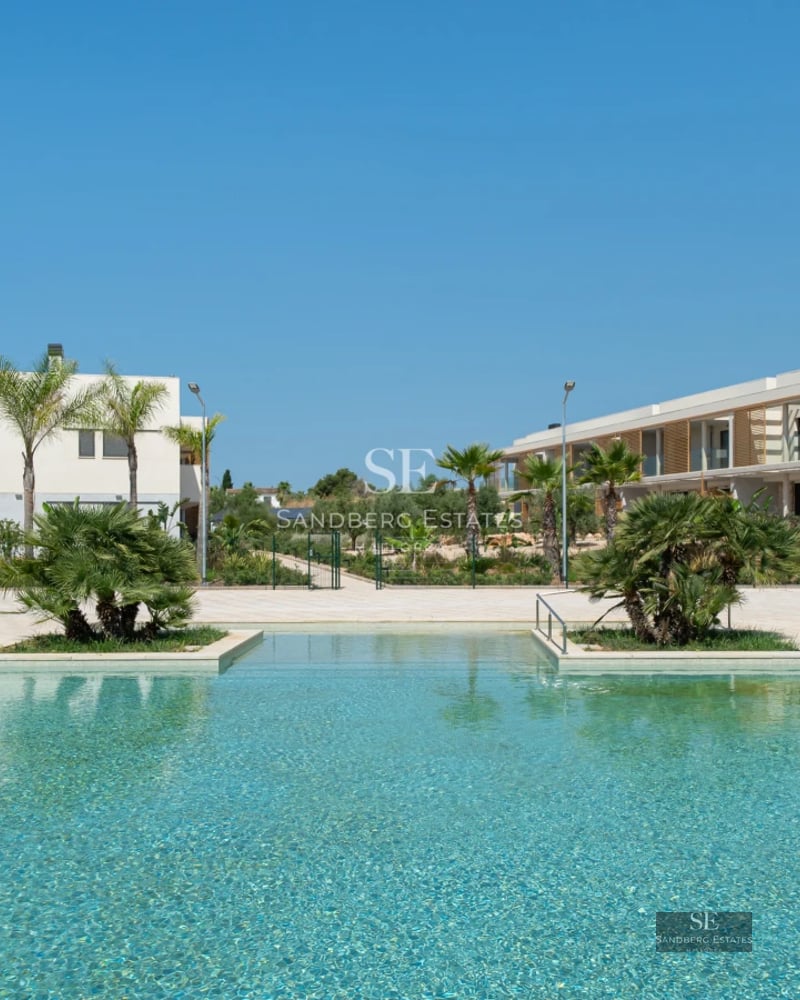 Spacious terrace with pool and lush garden. Modern architecture with large windows and stylish outdoor furniture.