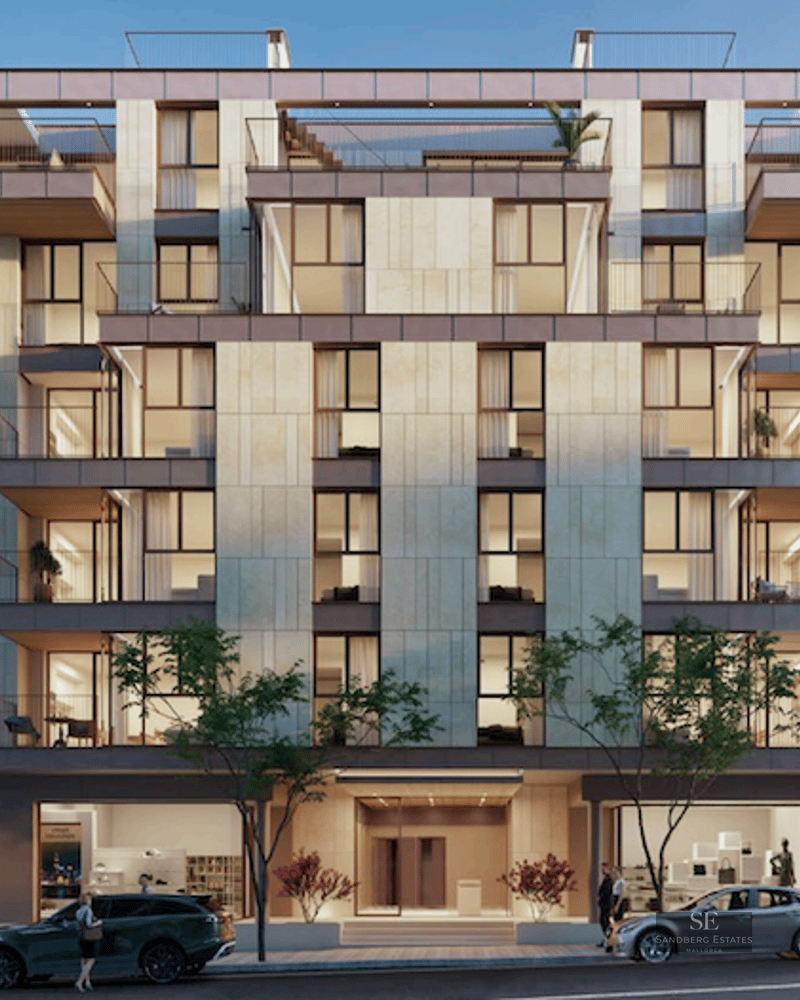 Front view of a contemporary six-story apartment building with beige stone cladding, large windows, and balconies.