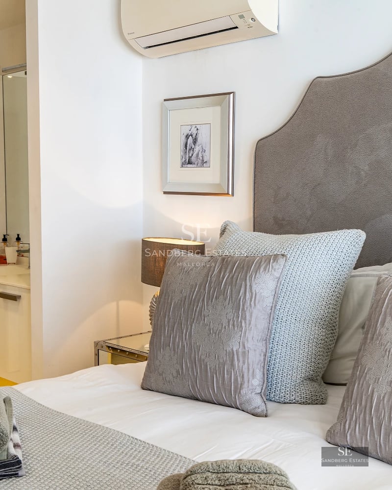 Spacious living room with panoramic windows, light wood flooring, modern design, gray sofas, and access to a terrace with a view. Elegance and comfort.