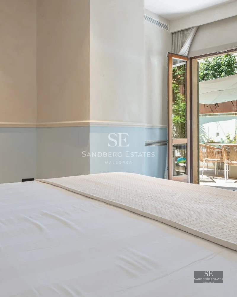 Spacious living room with large windows, panoramic sea views, a fireplace, and modern decor in neutral tones.