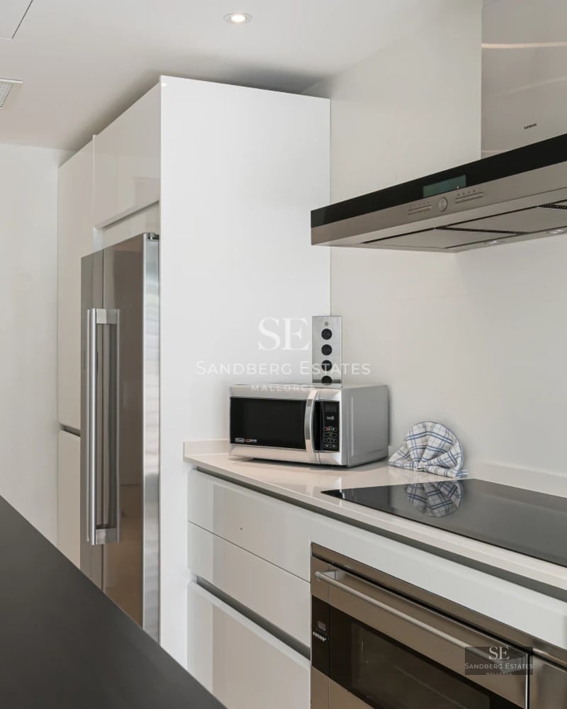 Spacious living room featuring large windows, light wood flooring, and elegant furniture. Panoramic sea views.