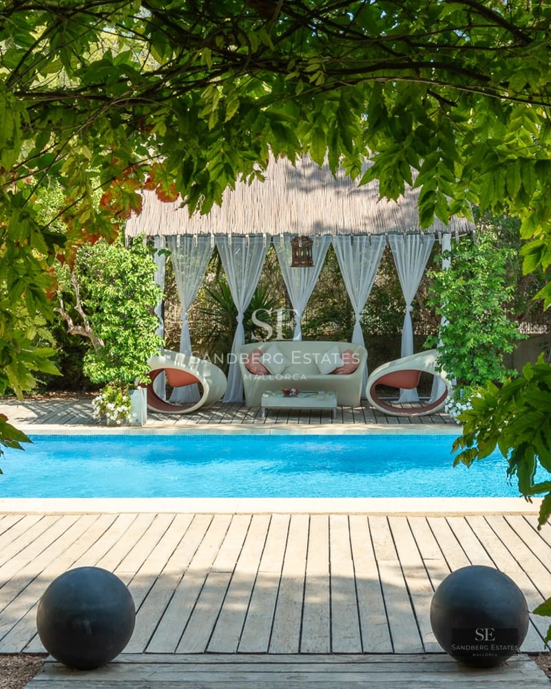 Exterior view of a modern villa with a pool, garden, and terraces. Minimalist architecture with large windows.