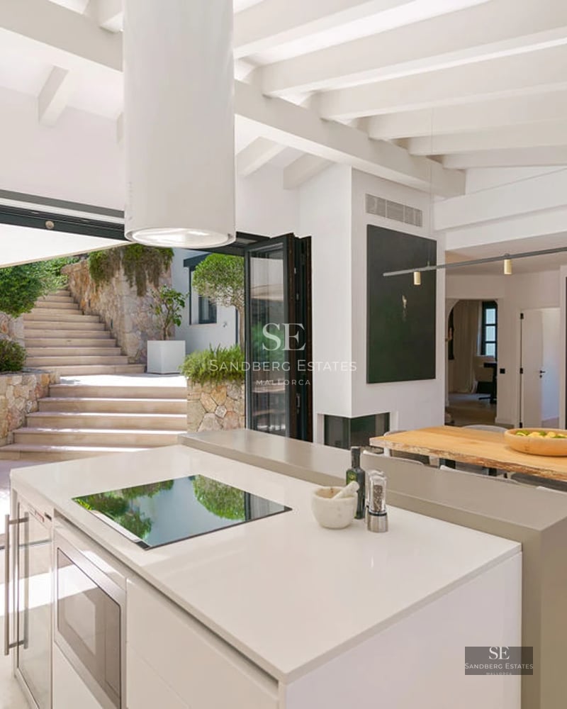 Spacious living room featuring large windows, a reflective pool, and modern design. Natural lighting and a neutral color palette.