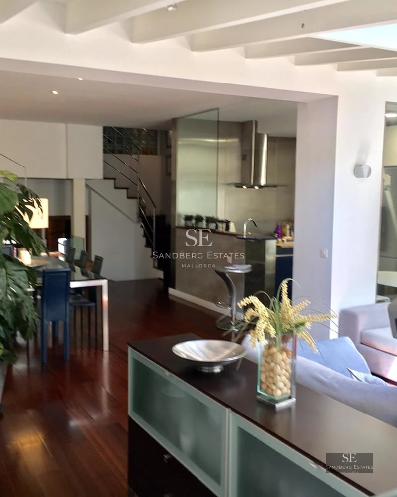 View of a modern villa with an infinity pool, sun loungers and lush vegetation. Clean and elegant architectural design.