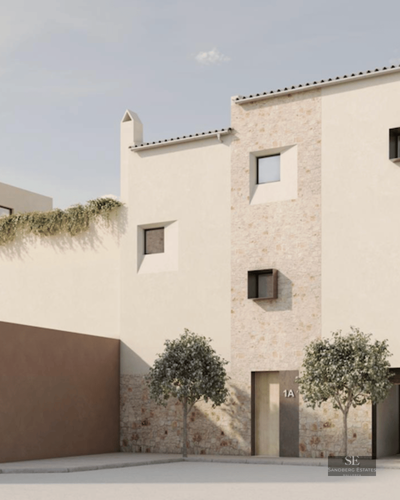 Modern stone and stucco building with minimalist windows and a car in the garage under bright daylight.
