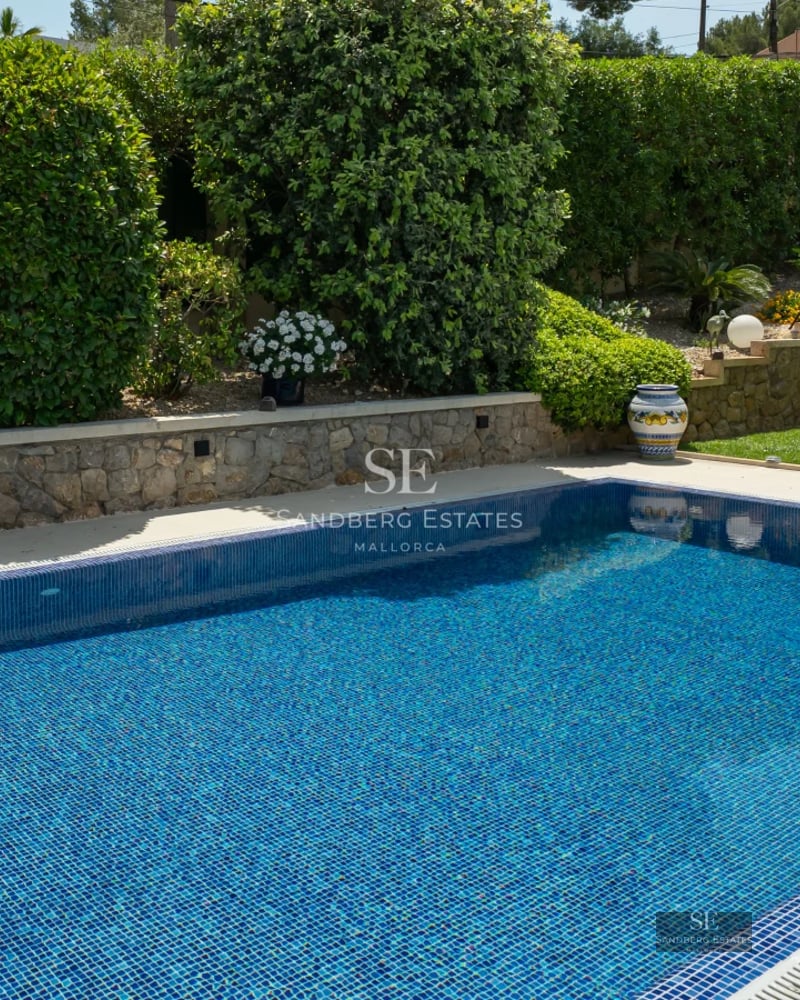 Exterior of a modern villa featuring a pool, garden, and large windows. Minimalist architecture. Elegant and contemporary design.