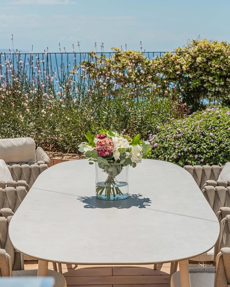 Exterior view of modern villa with reflecting pool. Minimalist architecture, large windows, and lush greenery.