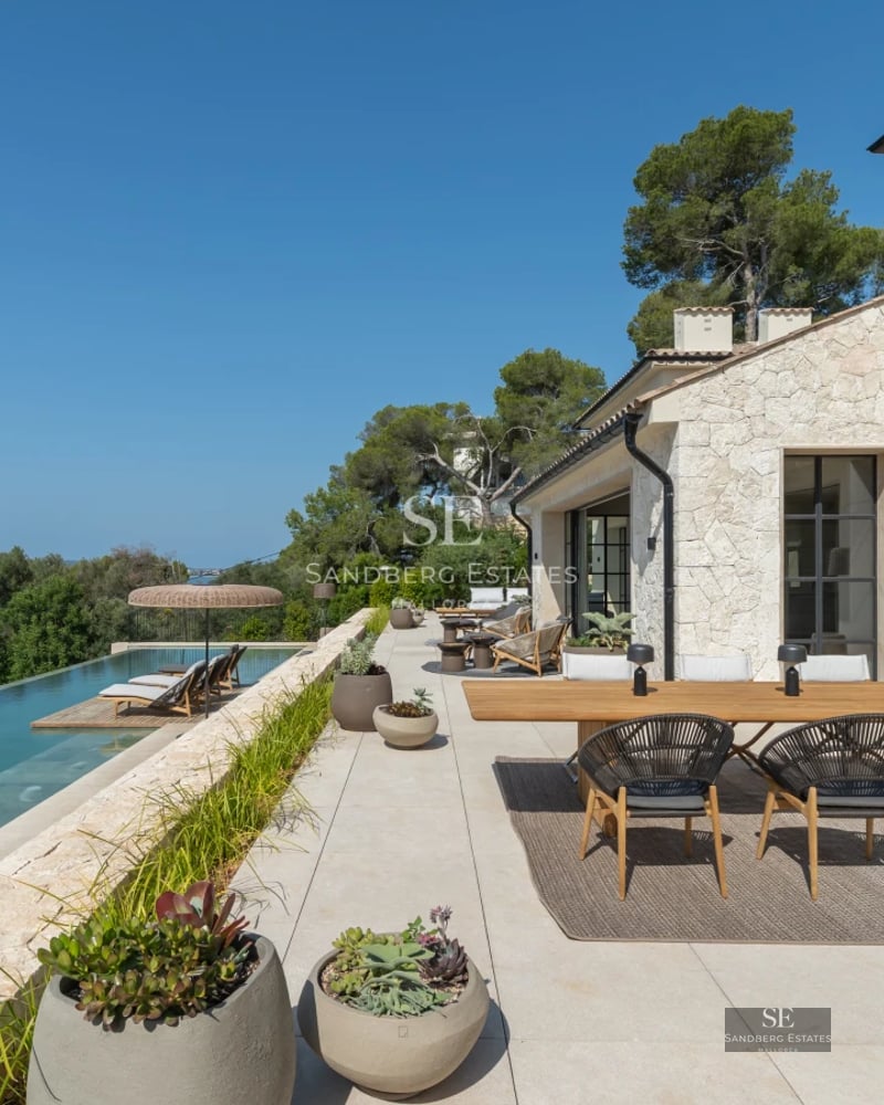 Spacious balcony with panoramic sea views. Modern design, glass railing, wooden floor. Elegant outdoor furniture.