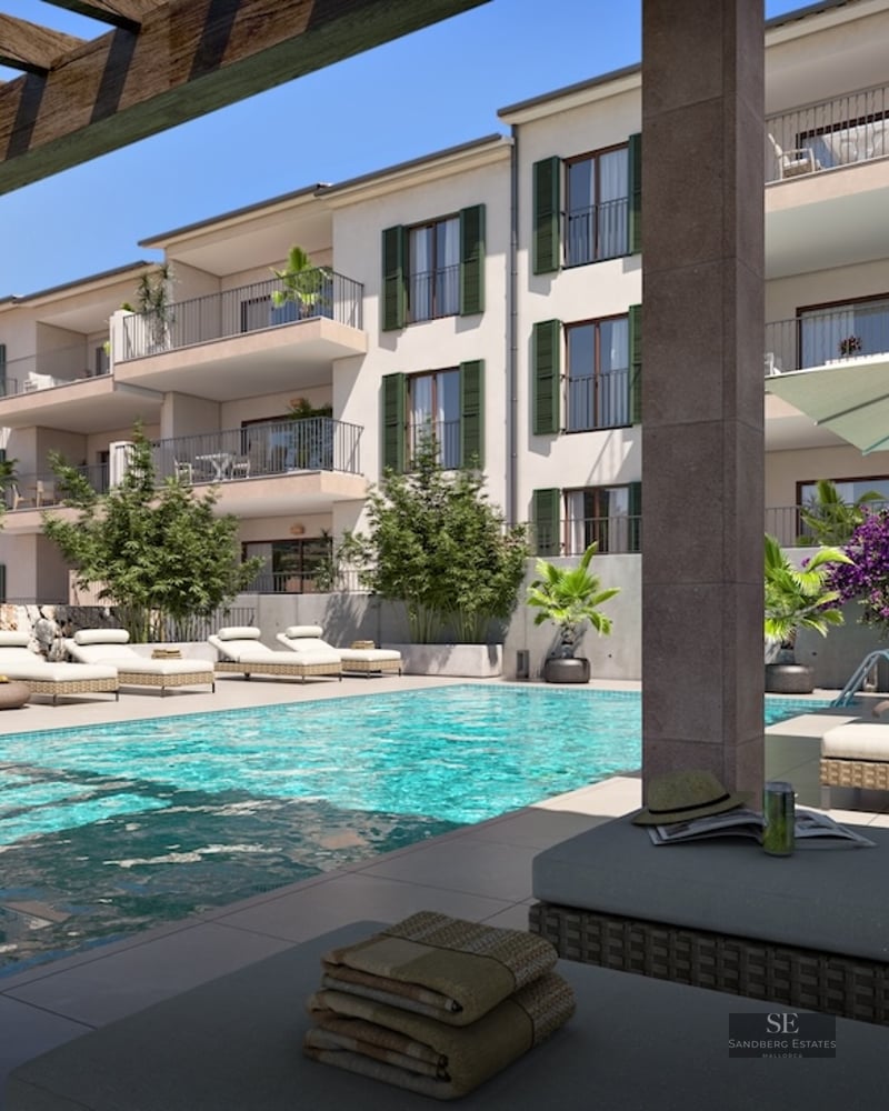 Modern turquoise pool area with sun loungers, umbrellas, and a wooden pergola next to a Mediterranean-style building.