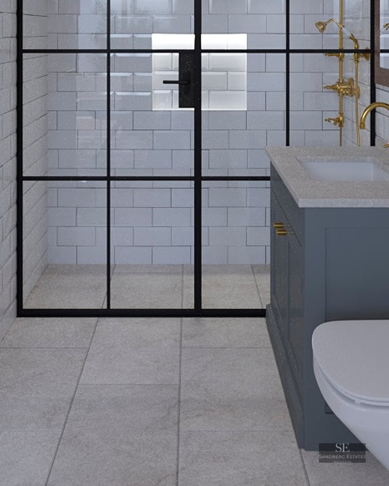 Modern bathroom featuring white subway tiles, a black-framed glass shower, and elegant gold faucets and fixtures.