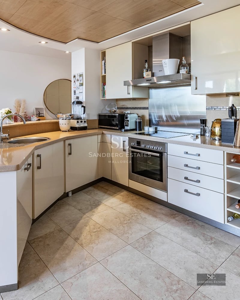 Spacious, bright living room with large windows, light wood floors, modern fireplace, and contemporary designer furniture. Panoramic views.