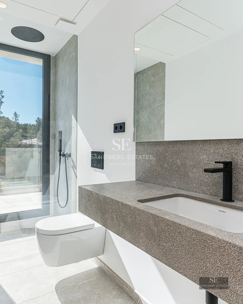 Vue d'une villa de luxe avec piscine, entourée de verdure. Architecture moderne avec de grandes baies vitrées et des finitions haut de gamme.