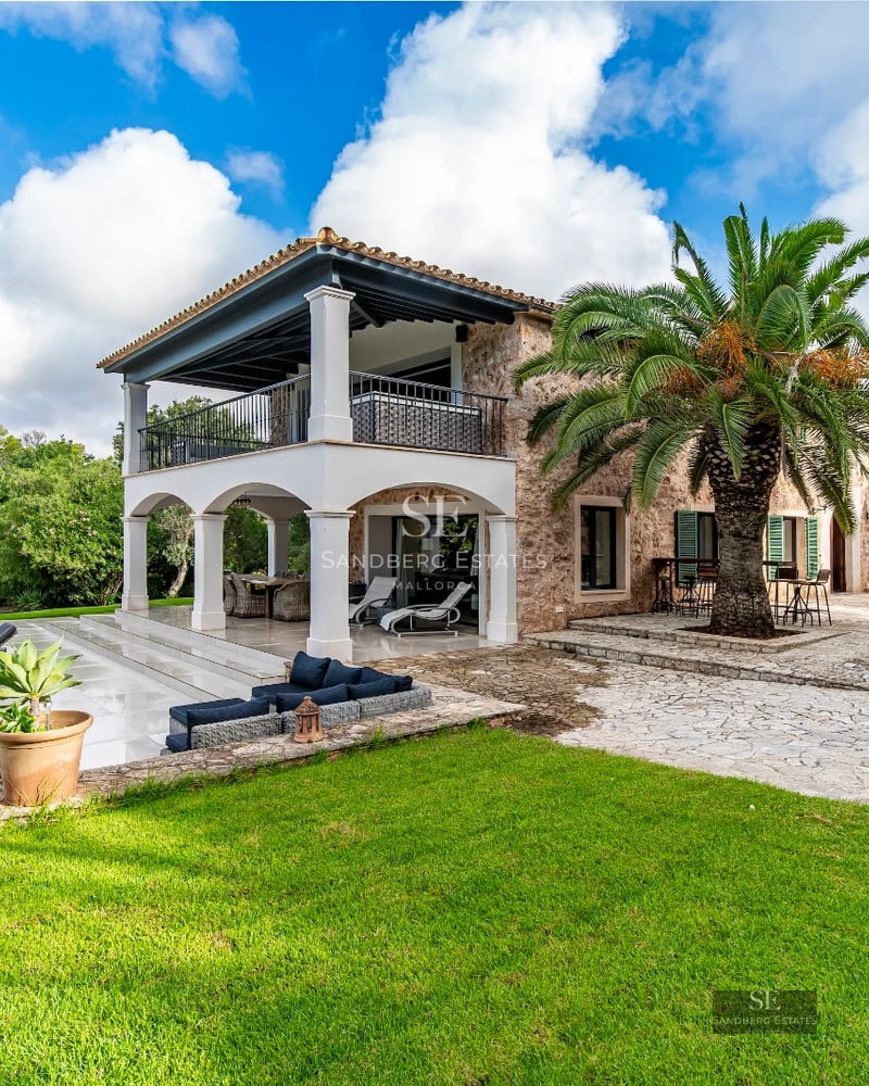 View of a modern infinity pool, surrounded by lush vegetation with a minimalist design house in the background.