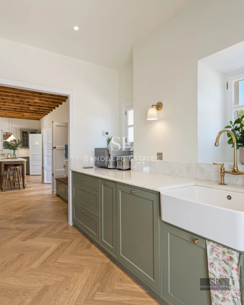 Spacious living room with floor-to-ceiling windows, designer sofas, modern rug, and fireplace. Natural light and panoramic views.