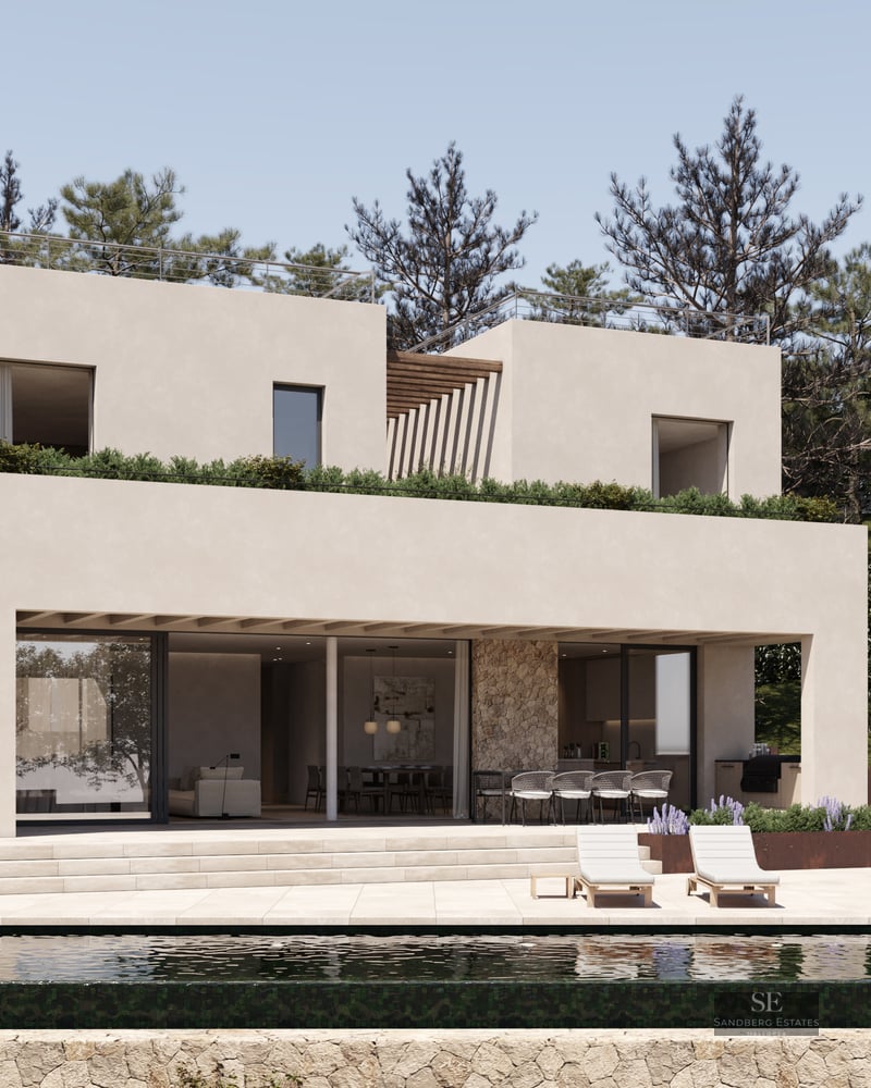 A modern two-story beige villa with an infinity pool, stone walls, and sun loungers under a clear sky.