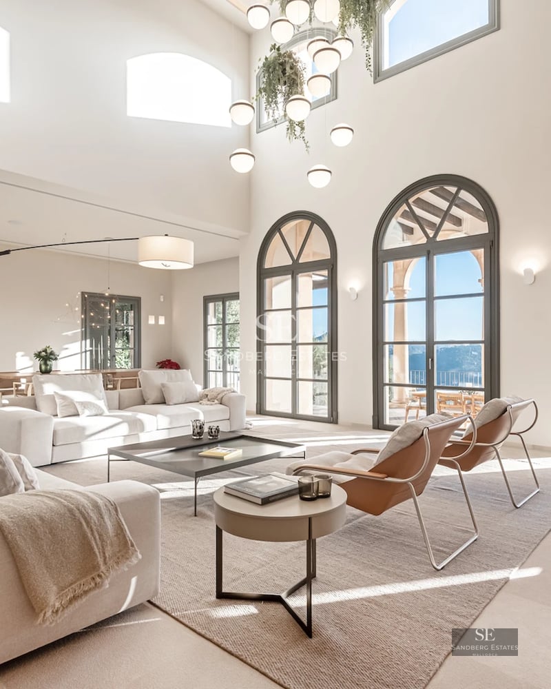 Spacious balcony with sea view. Glass railing, wooden floor, and modern outdoor furniture. Minimalist design with natural light.